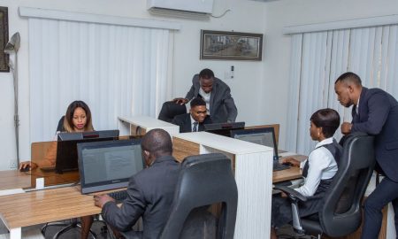 A group of professionals working together in a modern office setting, emphasizing teamwork and productivity.