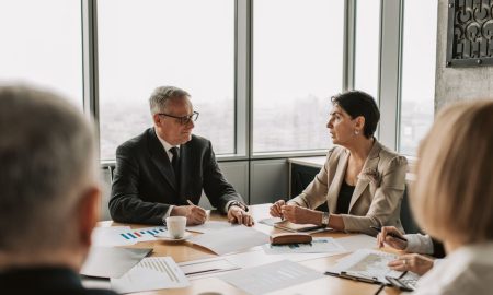 Business professionals engaged in a strategic meeting in a modern office setting with natural light.