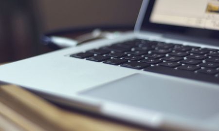 Focused image of a laptop keyboard on a table indoors, showing modern technology.