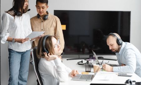 Diverse team of professionals collaborating in a modern office with tech gadgets and headsets.