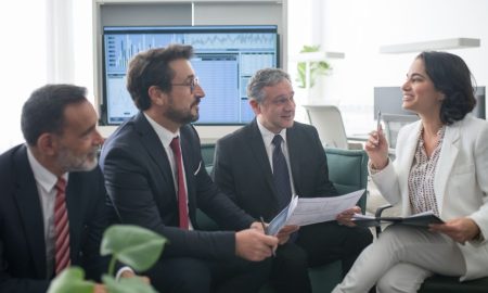 Diverse business professionals engaged in a lively office meeting, fostering collaboration and teamwork.