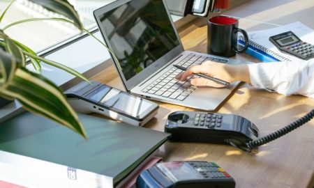 A bright modern office desk setup with electronic devices and plants, ideal for productivity.