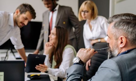 A diverse group of professionals engaging in a collaborative meeting in a modern office setting.